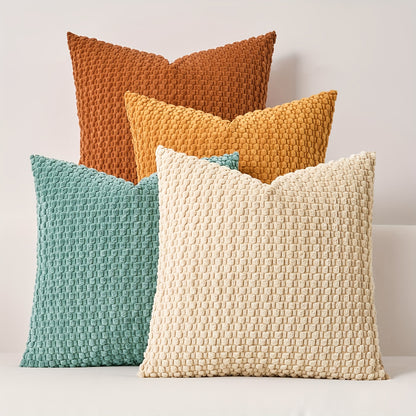 Four textured pillows in brown, yellow, blue, and beige on a light background