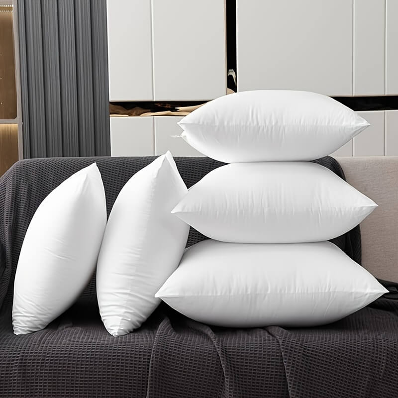 6 white throw pillows on a sofa sold by WorkZen Interiors