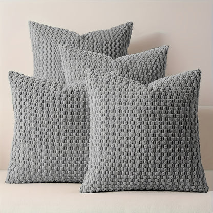 Three textured gray pillows on a neutral background