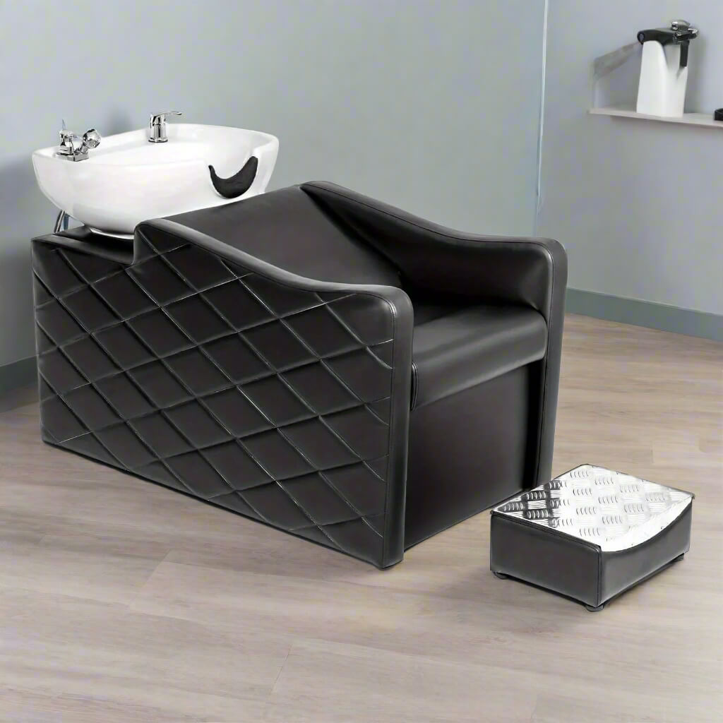 Black salon chair with white sink on a white background