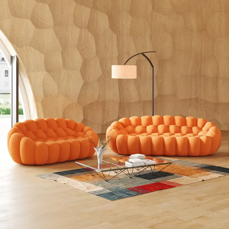 Orange bubble sofa set in a modern living room with a textured wall and floor lamp.