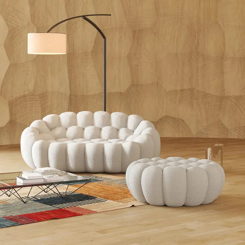 Modern living room with a white tbubble sofa and ottoman against a wooden wall.