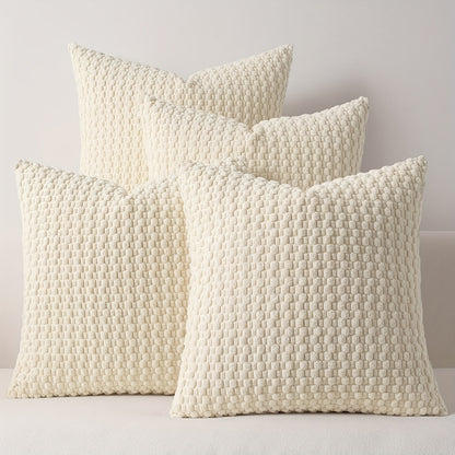 Four textured cream pillows on a light gray background