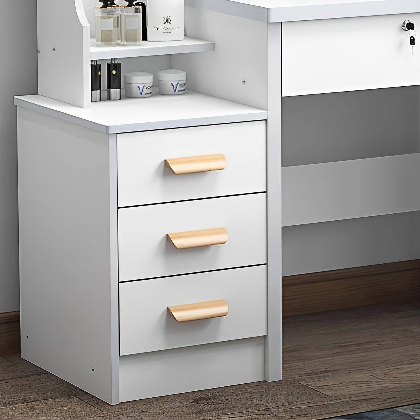 White dresser with three drawers featuring wooden handles in a room setting.