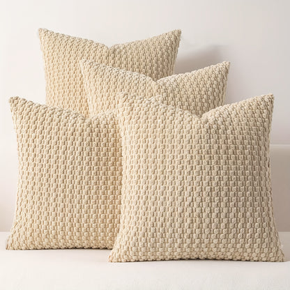 Three beige textured pillows on a white surface with a light gray background