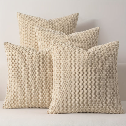 Three textured beige pillows on a white surface with a neutral background