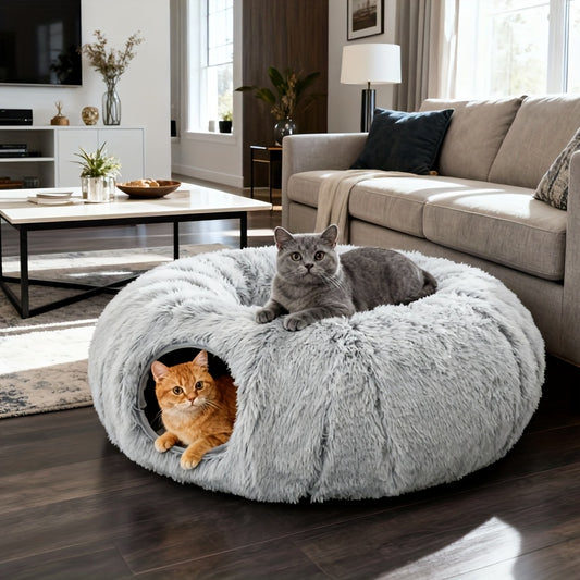 Two cats in a fluffy gray cat donut in a living room.