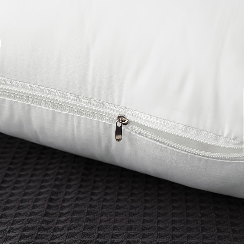 White pillow with a zipper on a textured black surface