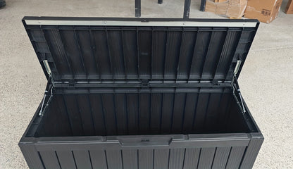 Black storage box with a lid on a concrete floor