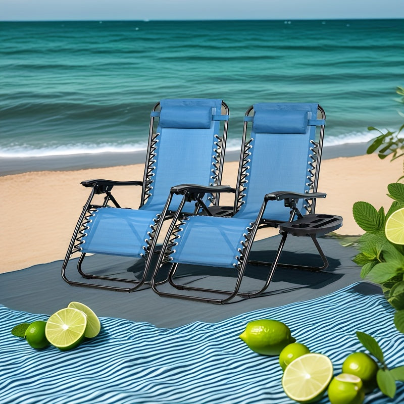 Two blue lounge chairs on a sandy beach with ocean view, surrounded by limes.