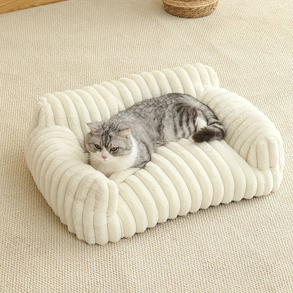Cat lying on a plush white cat sofa on a beige carpet