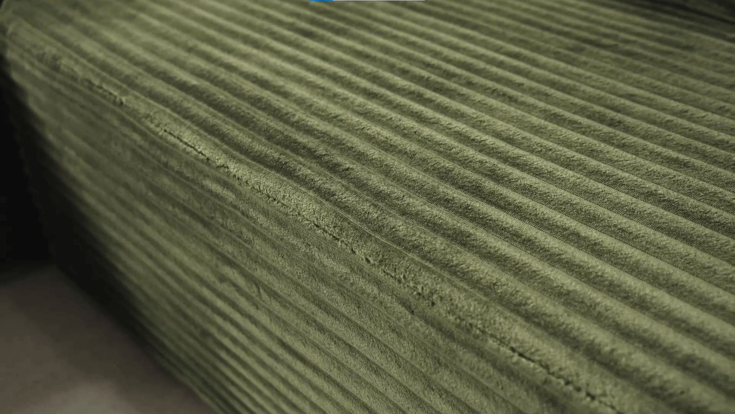 A green sectional sofa sold by WorkZen Interiors
