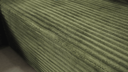 A green sectional sofa sold by WorkZen Interiors