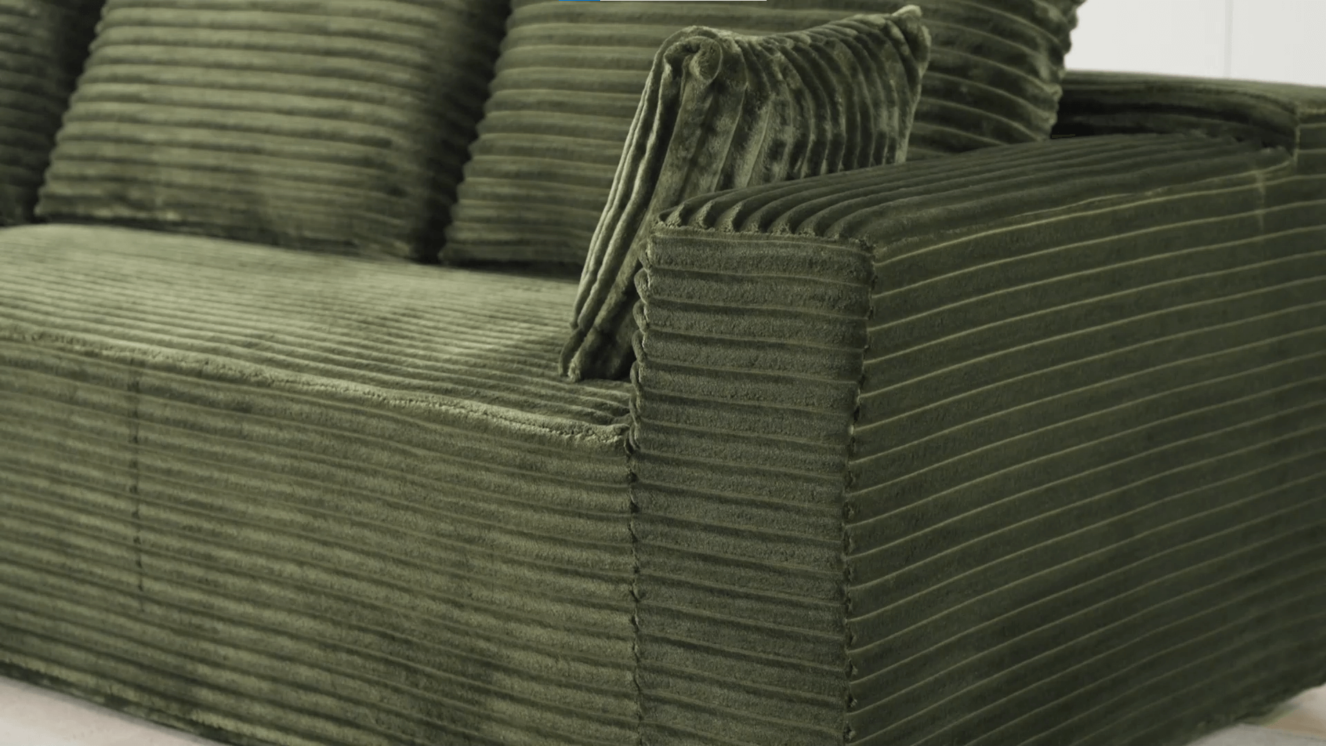 A green sectional sofa sold by WorkZen Interiors